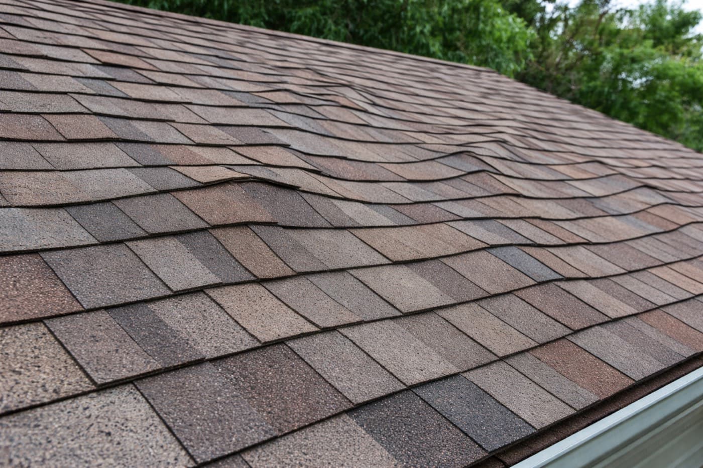 Asphalt shingle roof with a visibly wavy, uneven surface