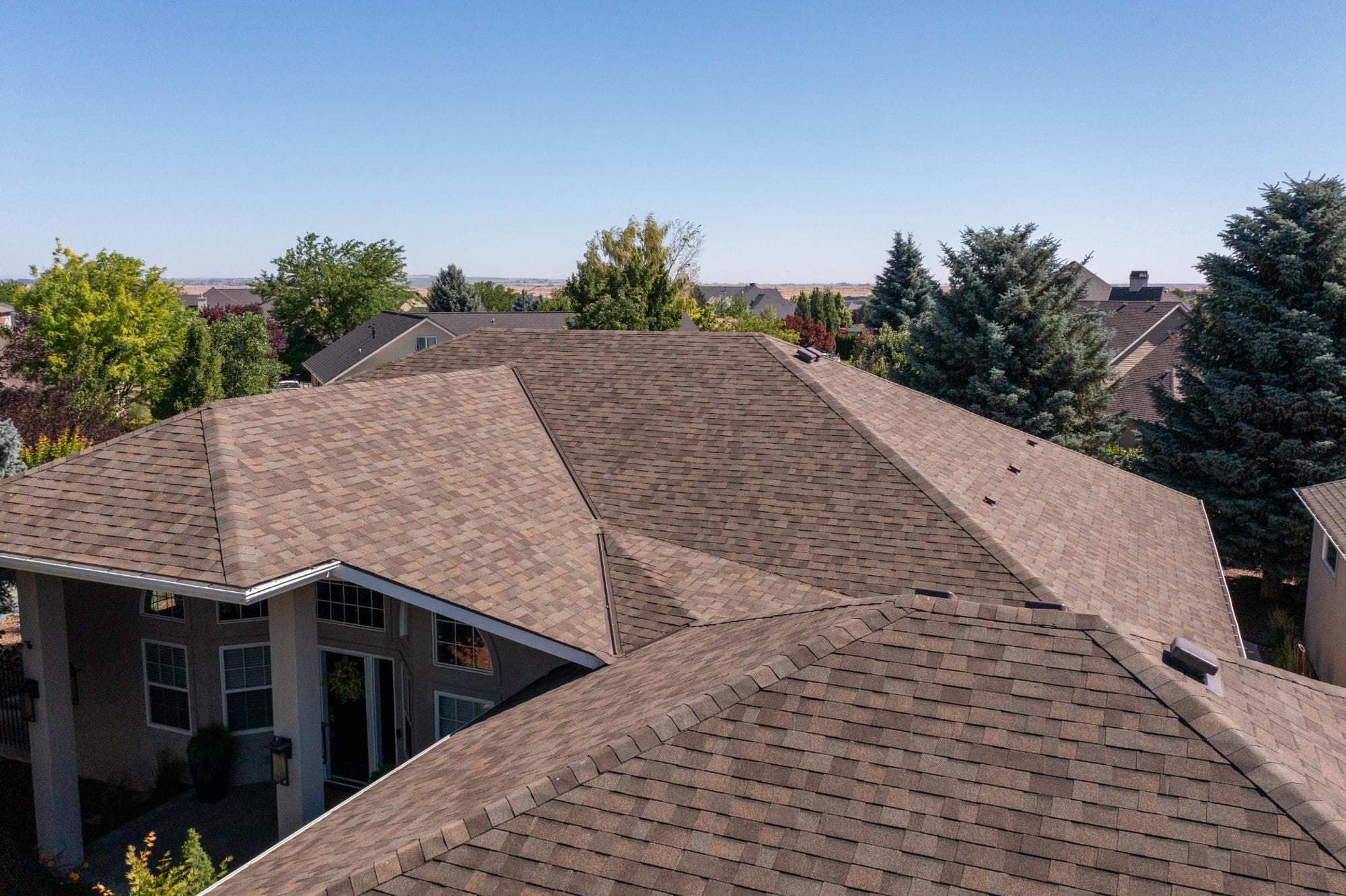Newly installed brown asphalt shingle roof on a single-story home